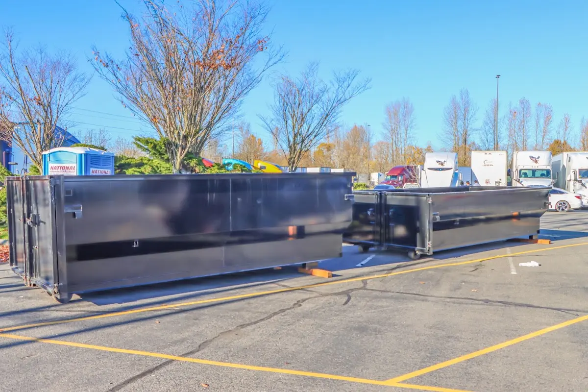 Professional dumpster rental service with roll-off container on residential driveway in Harahan